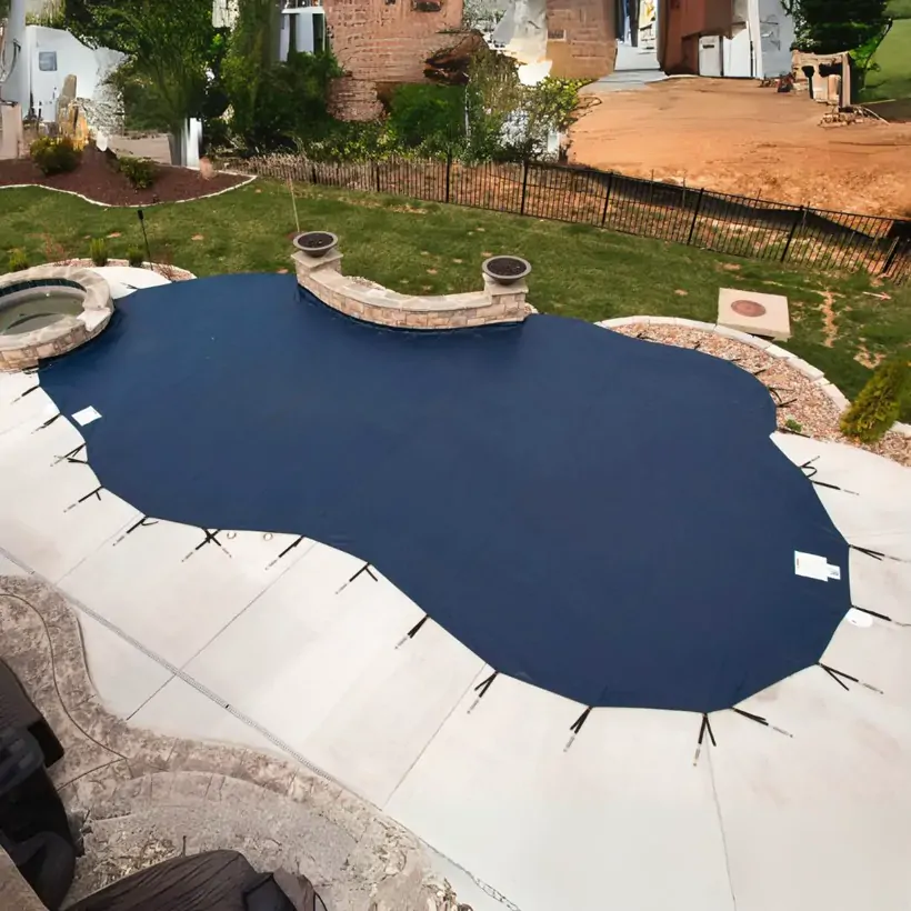 Inground pool under a winter safety cover during a seasonal pool closing in Westchester County