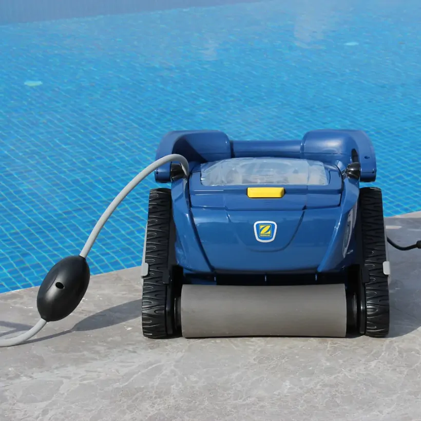 Robotic pool cleaner working along a tiled pool floor during weekly pool maintenance